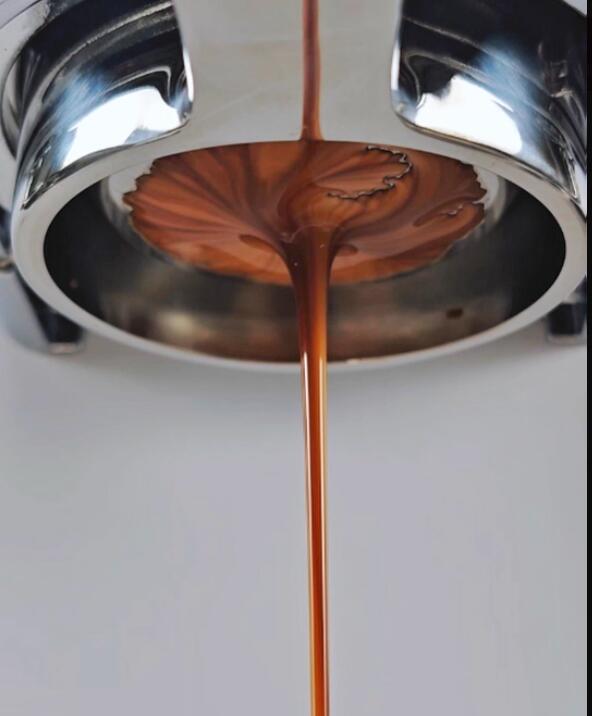 Espresso extracting from a bottomless portafilter into a single central stream